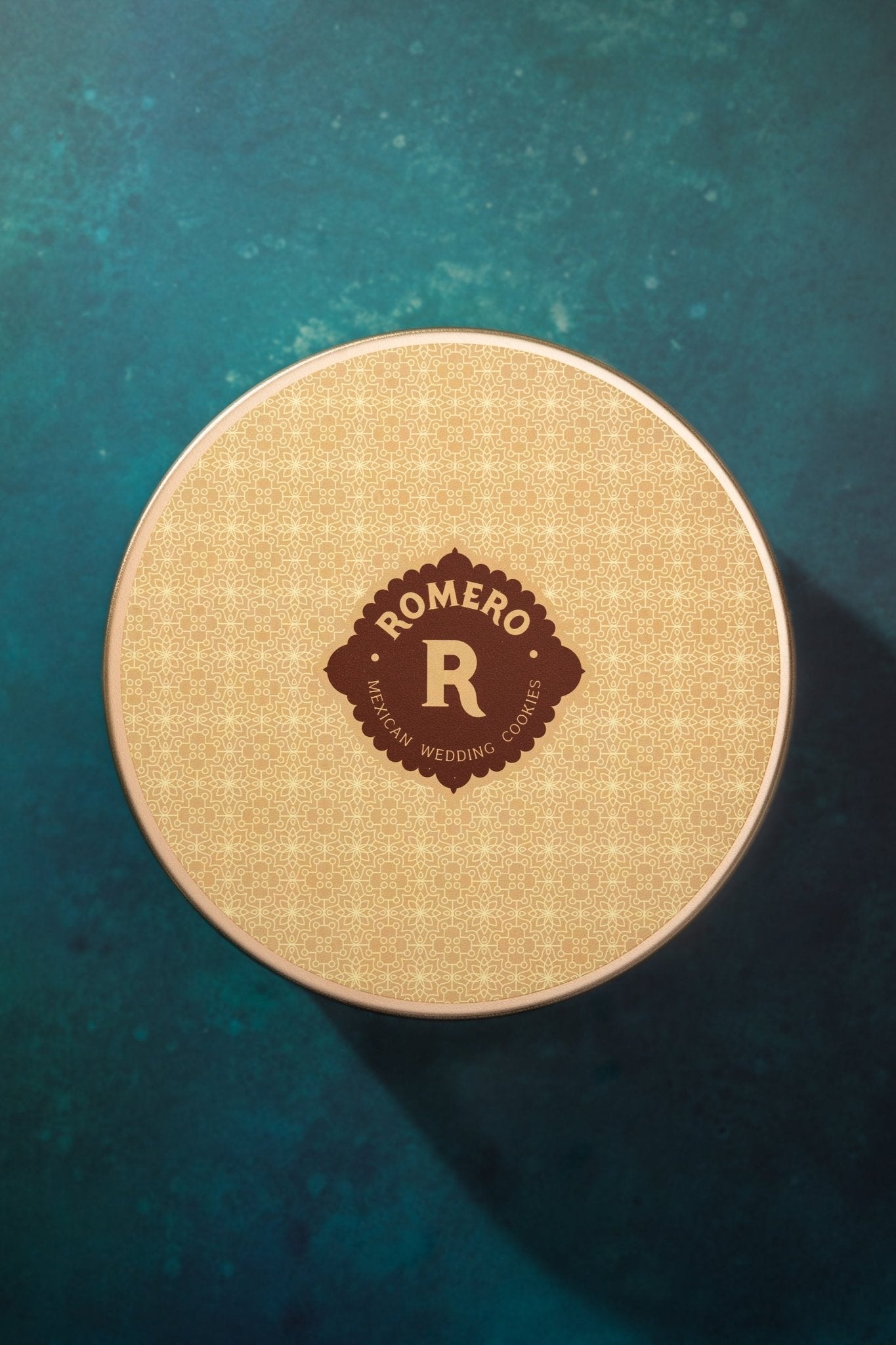 one large closed gold cookie tin on dark green background