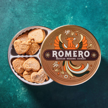 Romero Mexican wedding cookies in a decorative tin on a teal background