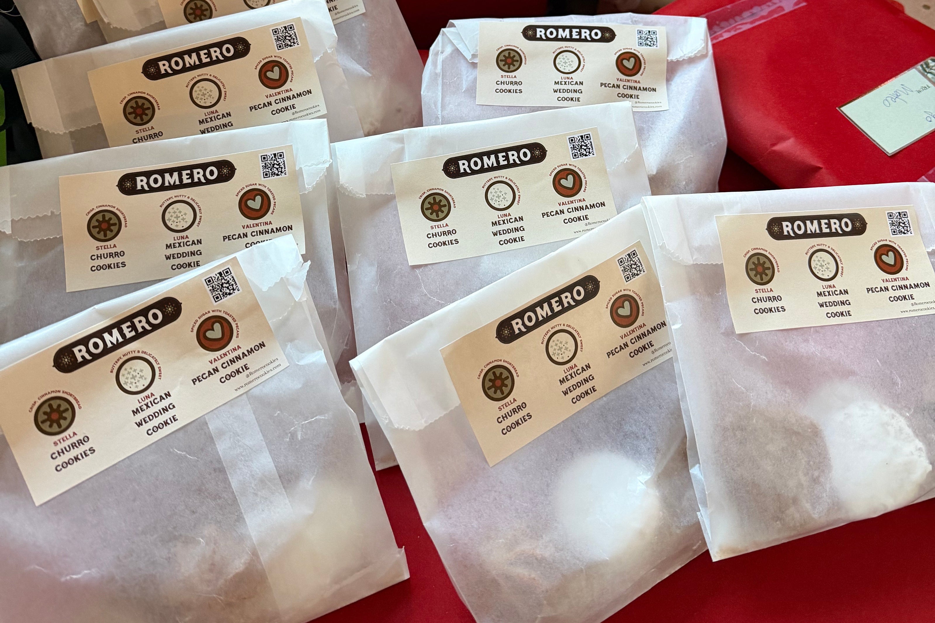 Packages with labels on a red surface, surrounded by Christmas decorations.