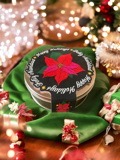 poinsettia paper band wrapped around a cookie tin against a christmas backgroud with lights