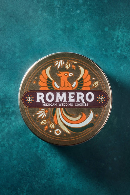 closed romero mexica cookie tasting set tin showing full logo on front against a dark green background