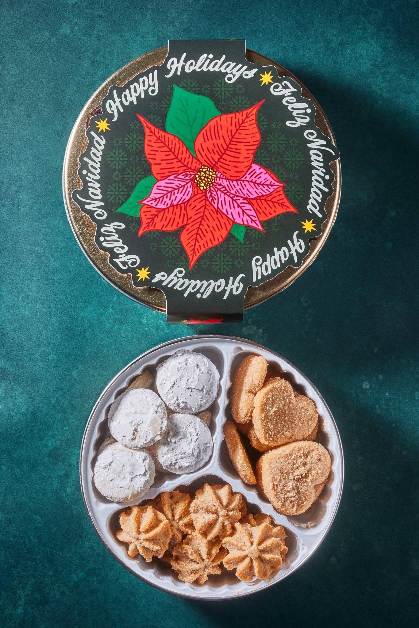 poinsettia paper band against dark green background with open cookie tin showing a variety of mexican cookies