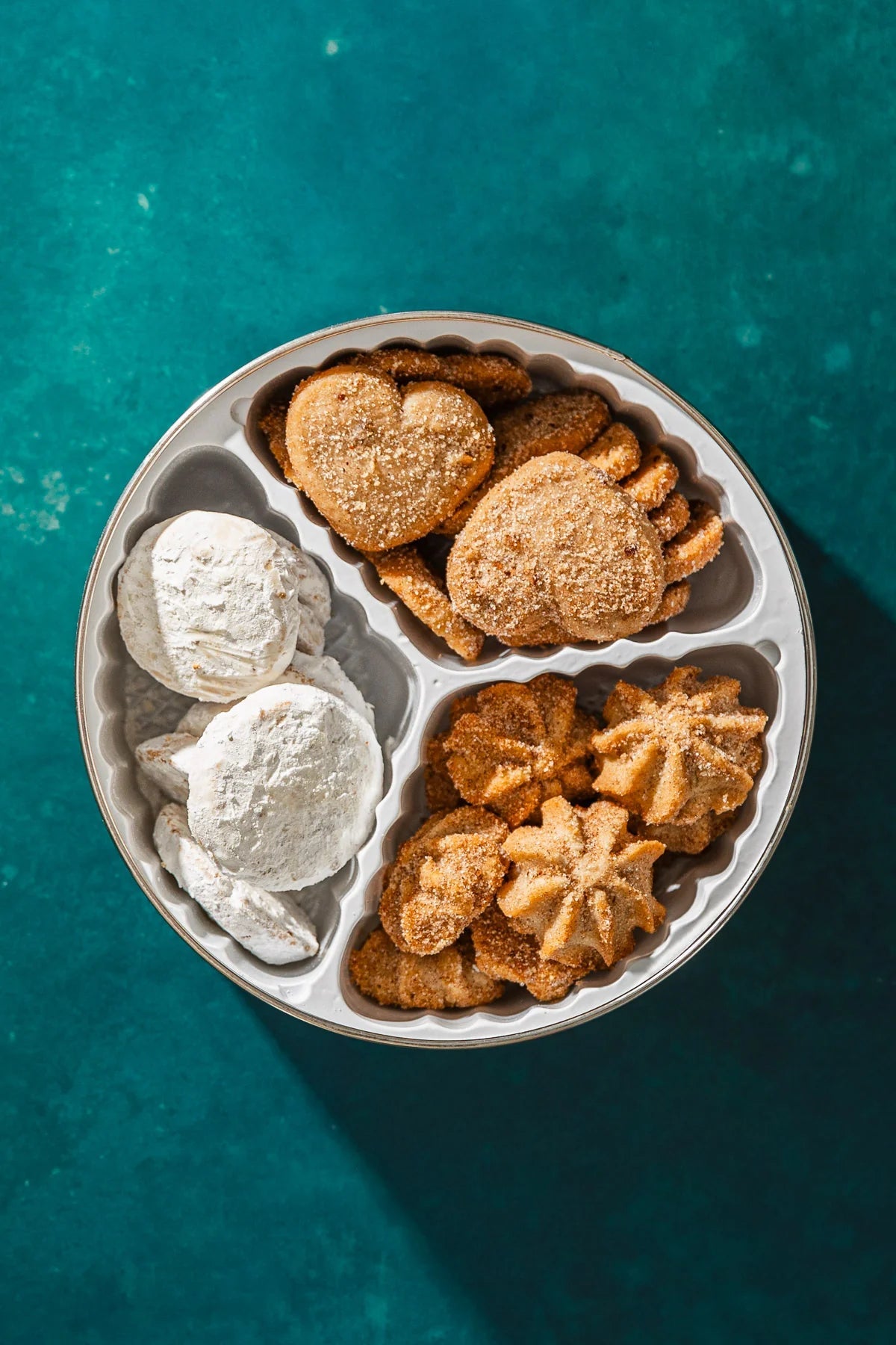 open cookie tin showing three types of mexican cookies in a 3 cavity set