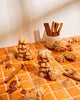 Spiced churro cookies on a tiled surface with cinnamon sticks and nuts