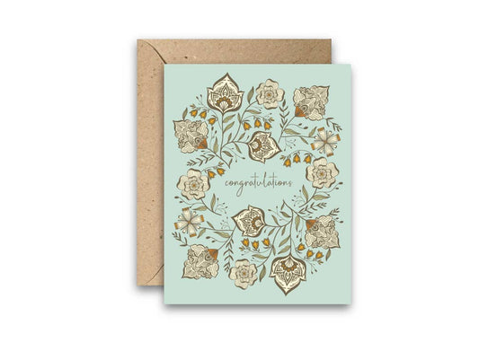 Greeting card with floral design and 'Congratulations' text on a light blue background, with a brown envelope.