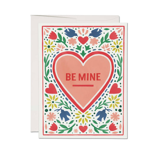 Greeting card with a heart and 'Be Mine' text on a floral patterned border.
