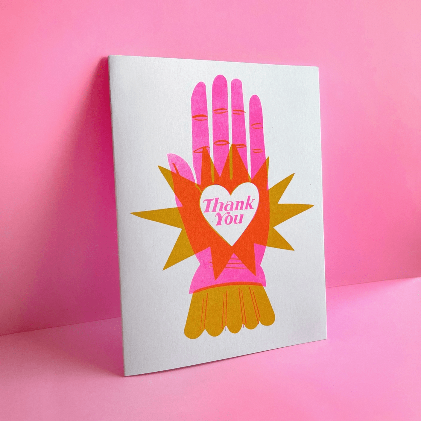 Card with colorful illustration of hands holding a heart and 'Thank You' text on a pink background