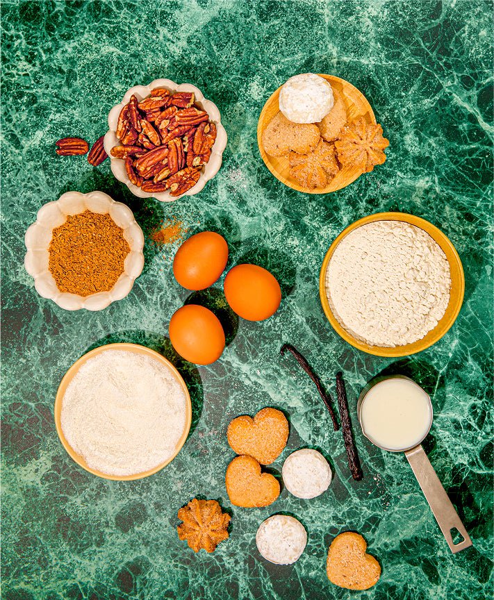 Mexican heritage cookie assortment on dark surface with fresh greenery, Romero variety tin styled for gifting