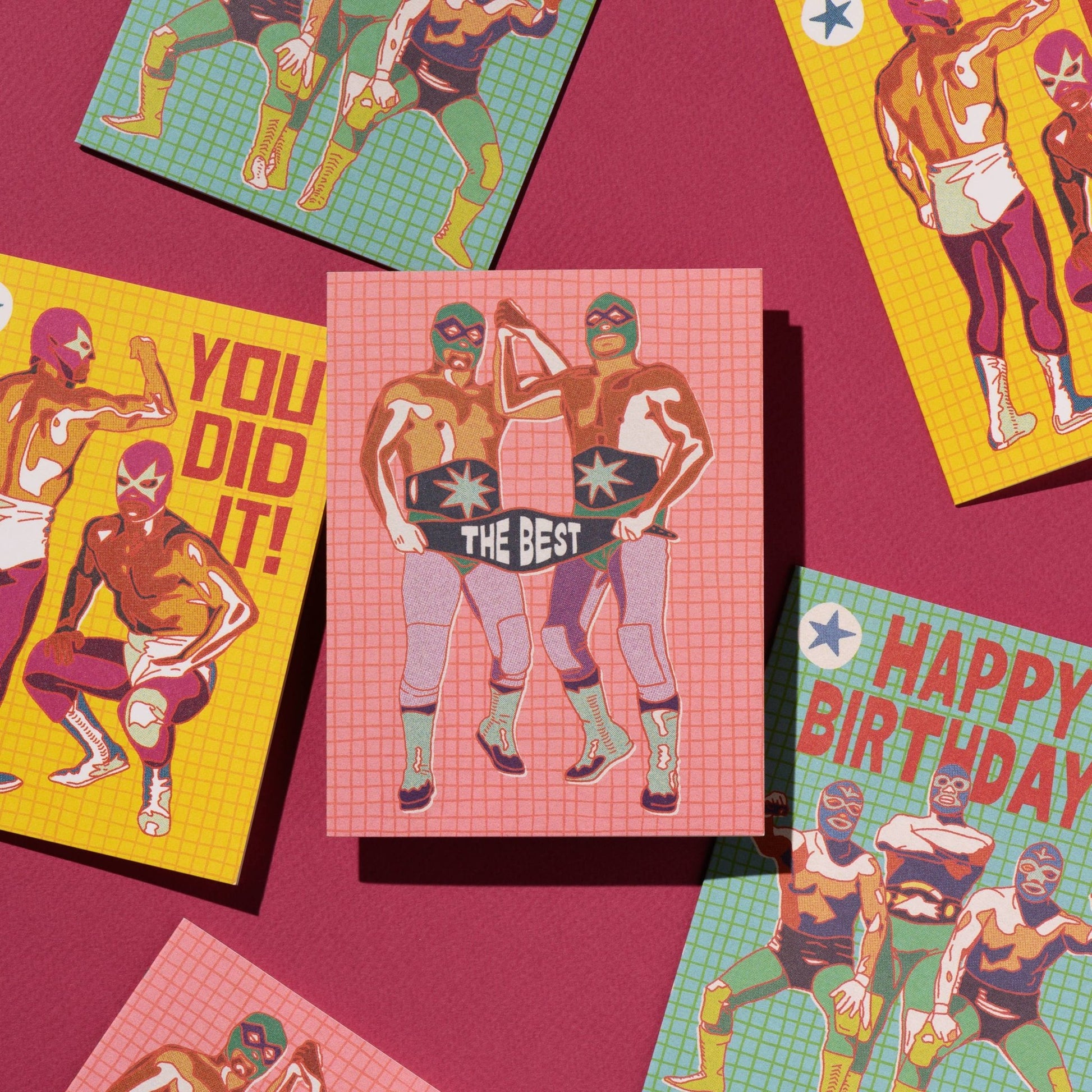 Colorful greeting cards with superhero designs on a pink background