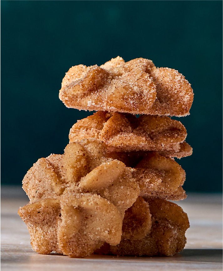 Stack of Stella mexican churro cookies on dark backdrop, bite-size heritage cinnamon cookies for gifting