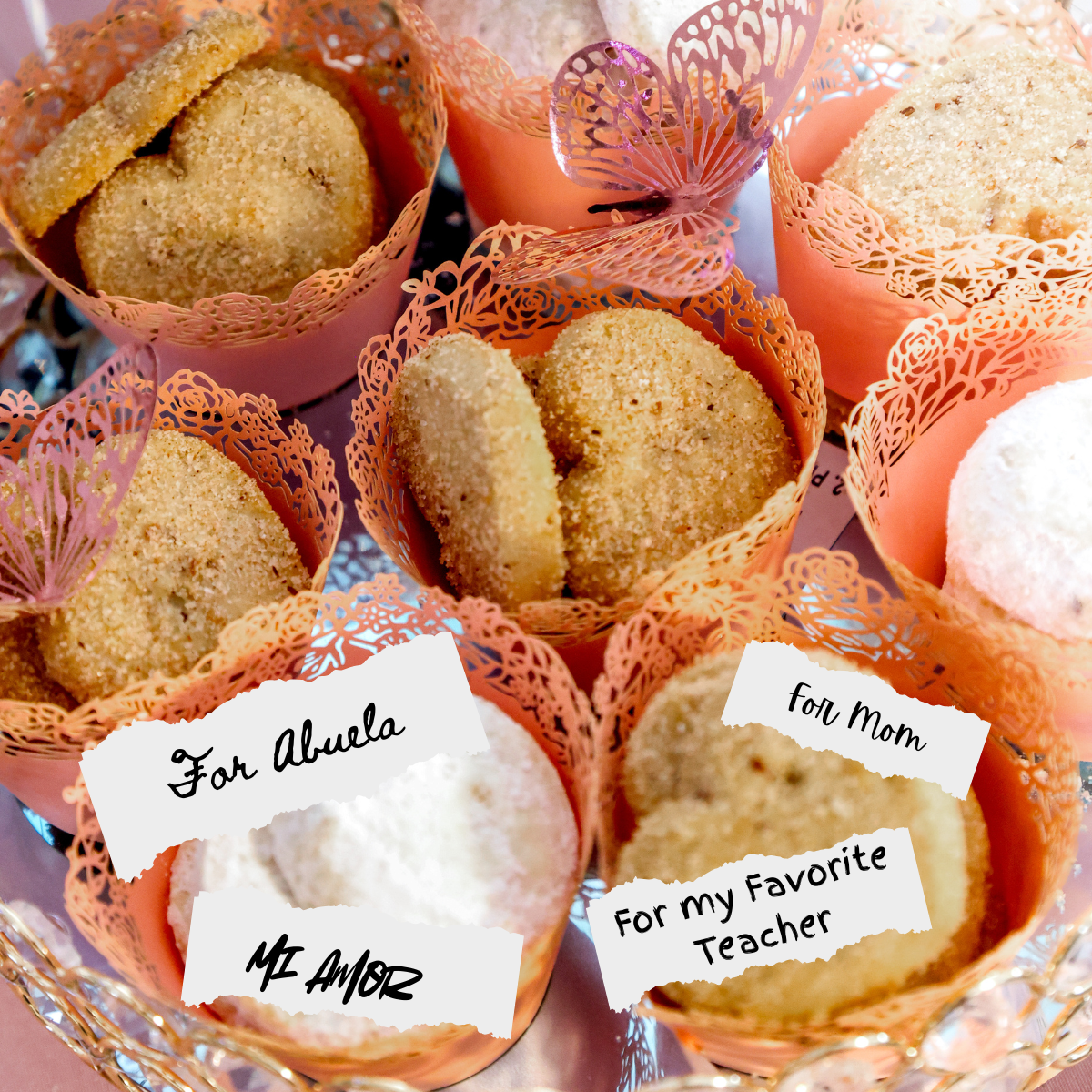 Cupcakes in decorative wrappers with personalized labels on a reflective surface