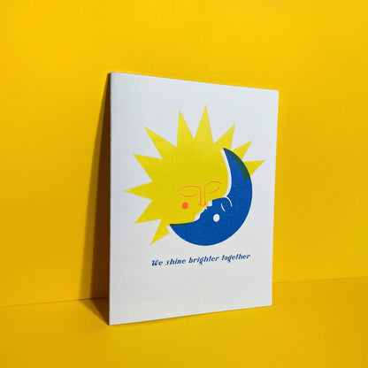 Card with sun and moon design and 'We shine brighter together' text on a yellow background